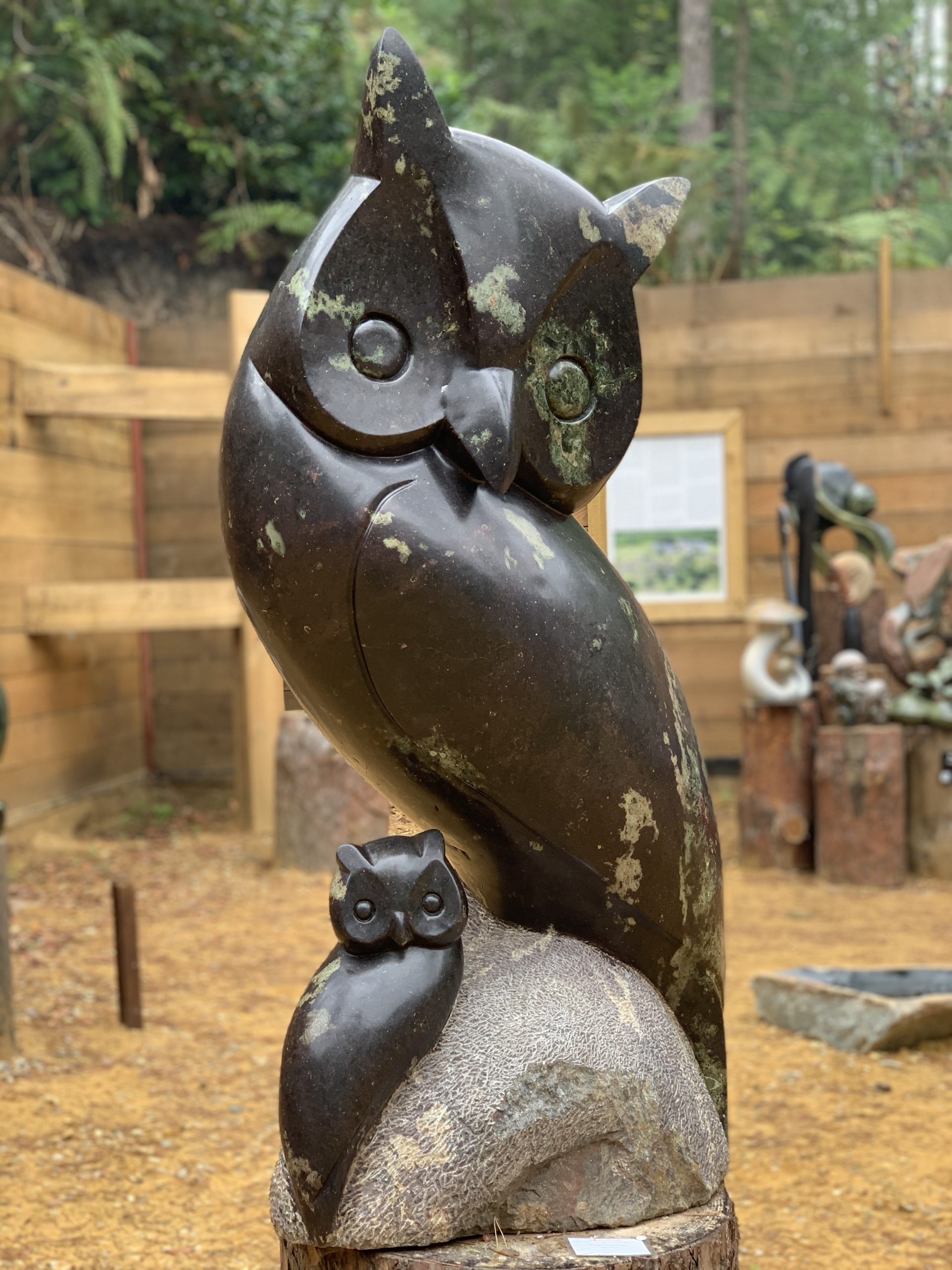A shona cobalt stone sculpture of an owl with another smaller owl perched on a rock.