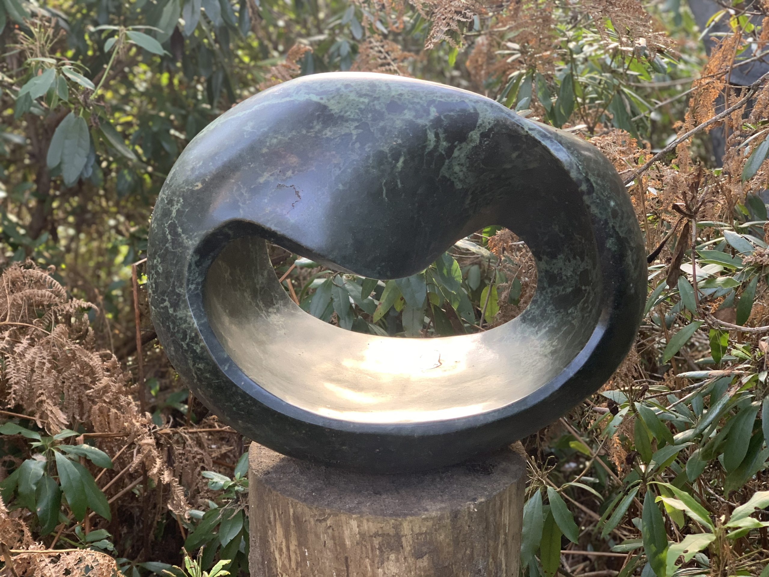 A Shona opal stone sculpture of an abstract curving shape.