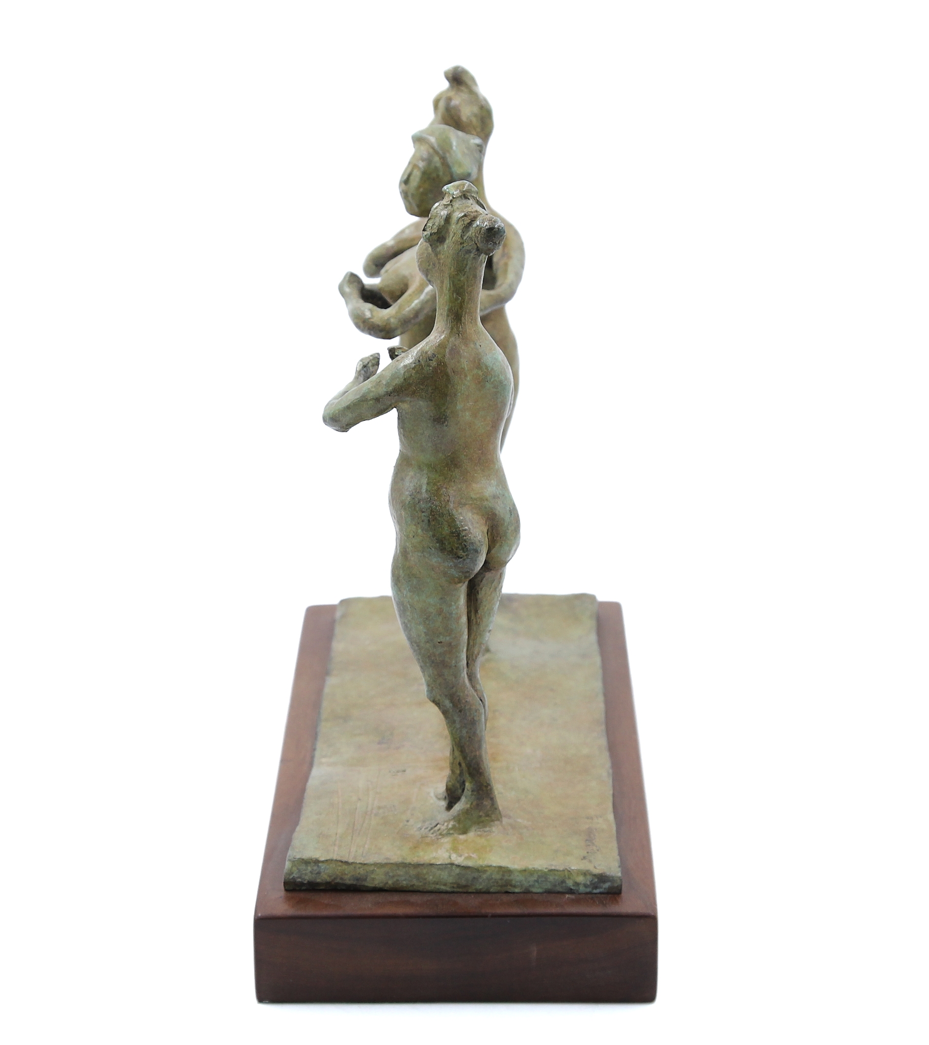 A bronze smaller scale sculpture showing three female figures stood up with their hands together.