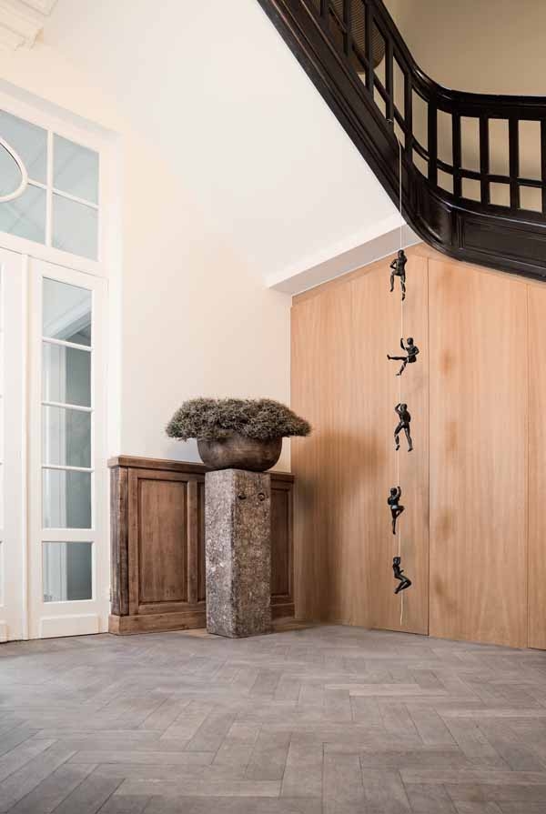 Grimpeurs Sociaux by P. Masaro is a figurative bronze sculpture of a group of five people climbing a rope.