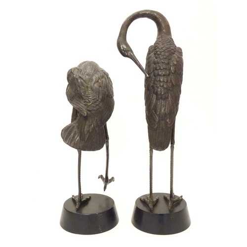 Pair of two bronze Cranes, One standing on one leg, the other standing on both legs.