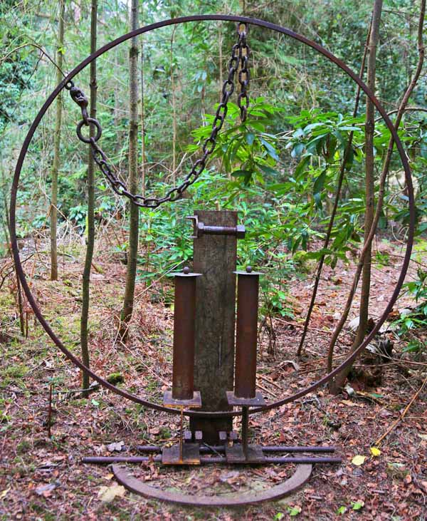 A furniture welded steel sculpture of a large abstract toilet roll holder.