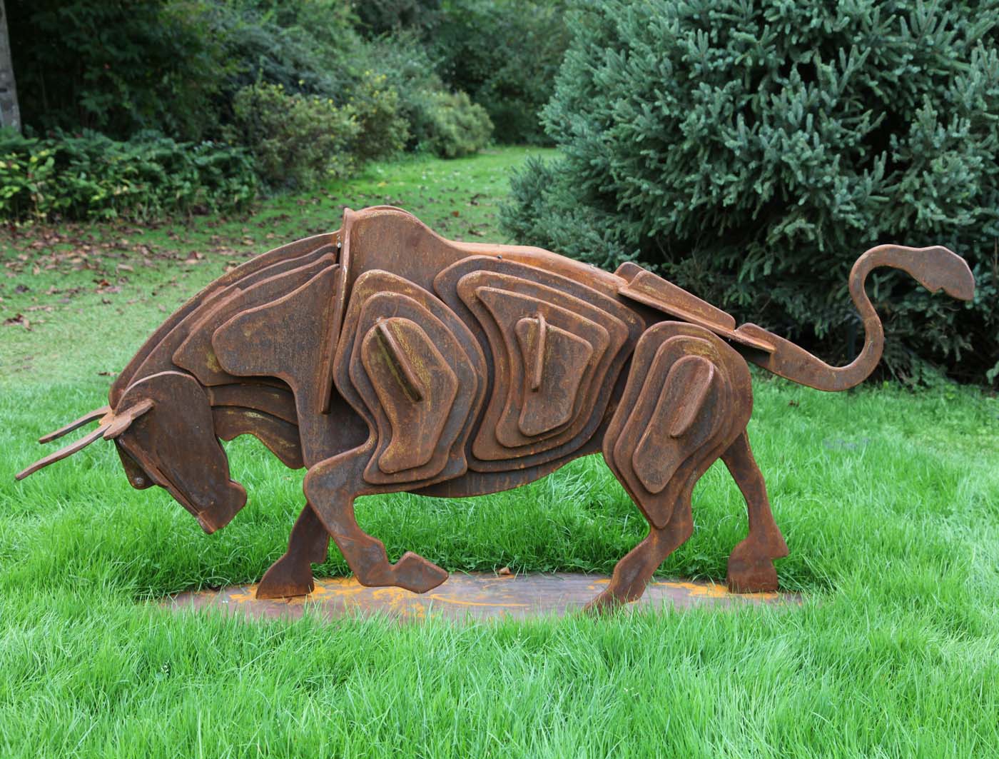 A modern steel sculpture of a bull with its head down preparing to charge.