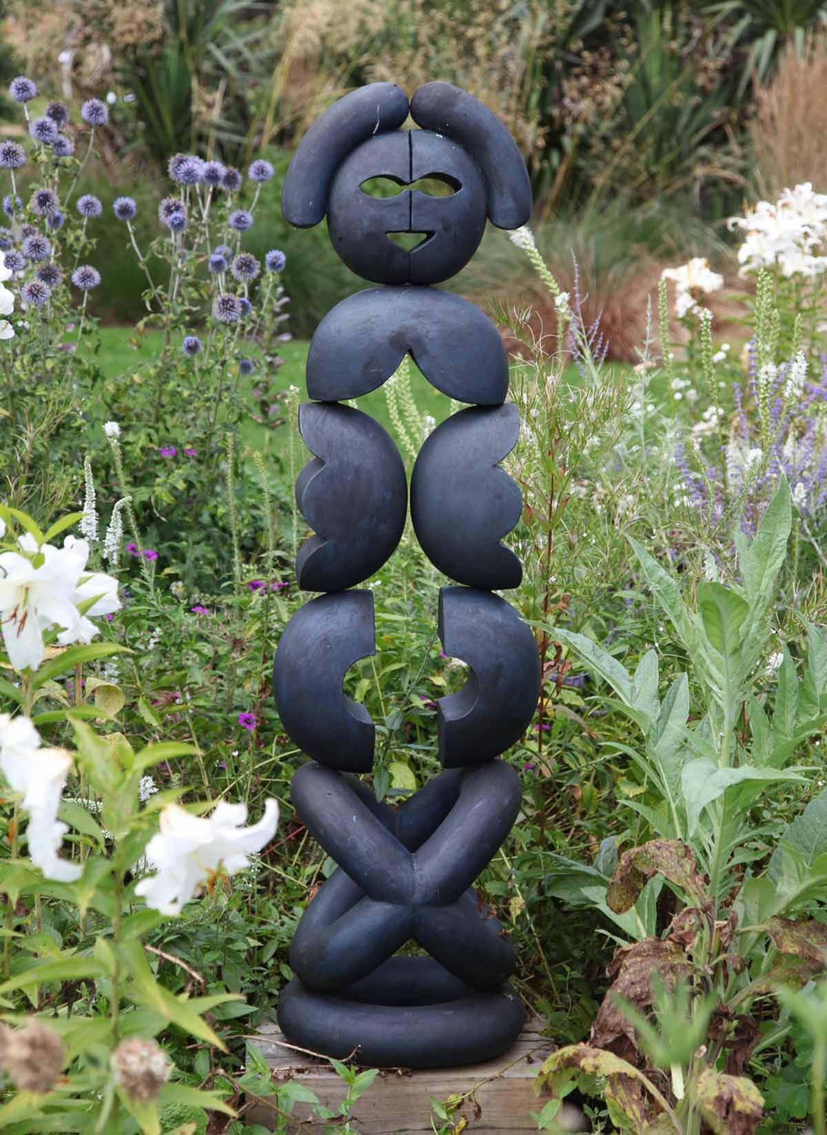 An abstract stone and wood sculpture of a variety of shaped stacked on top of each other