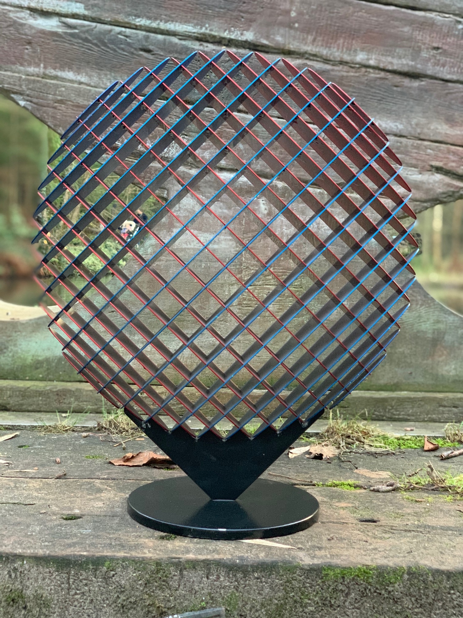 A abstract metal sculpture of a circle that changes colour depending on where it's viewed from.