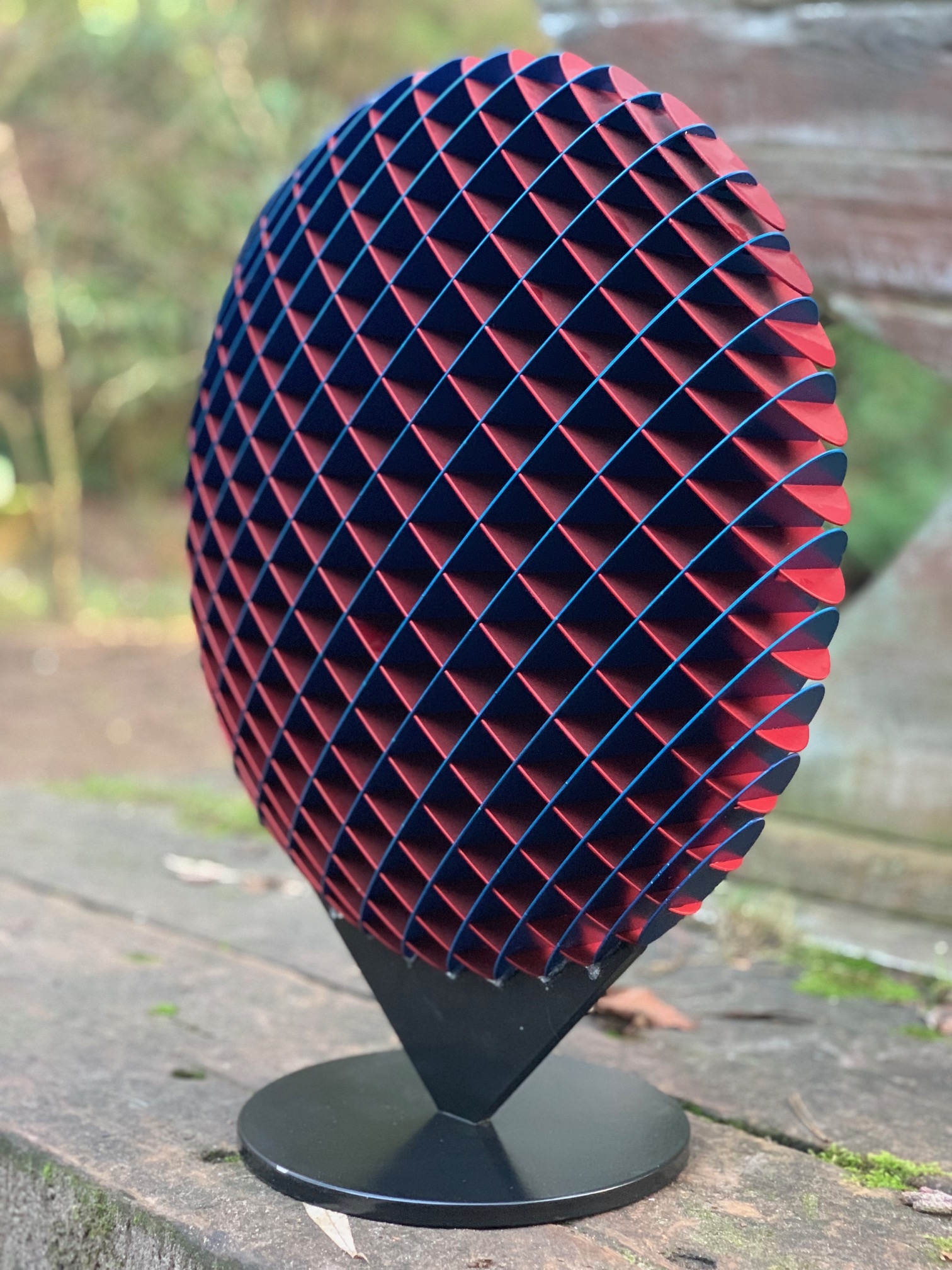 A abstract metal sculpture of a circle that changes colour depending on where it's viewed from.