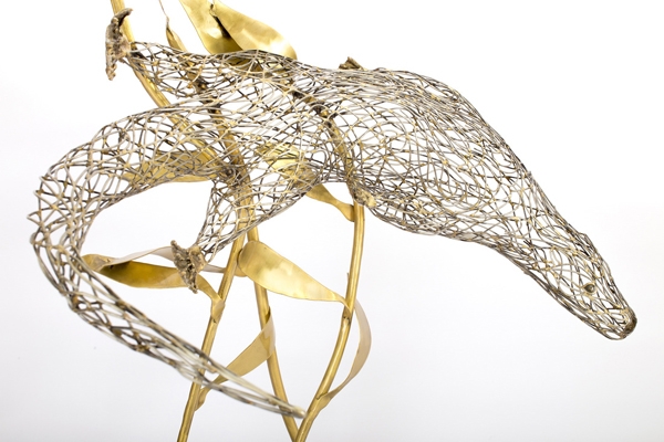 A figurative steel and brass sculpture of an Otter swimming through reeds and water.