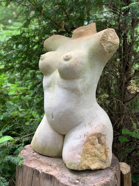 A shona stone sculpture of a woman's bare torso.