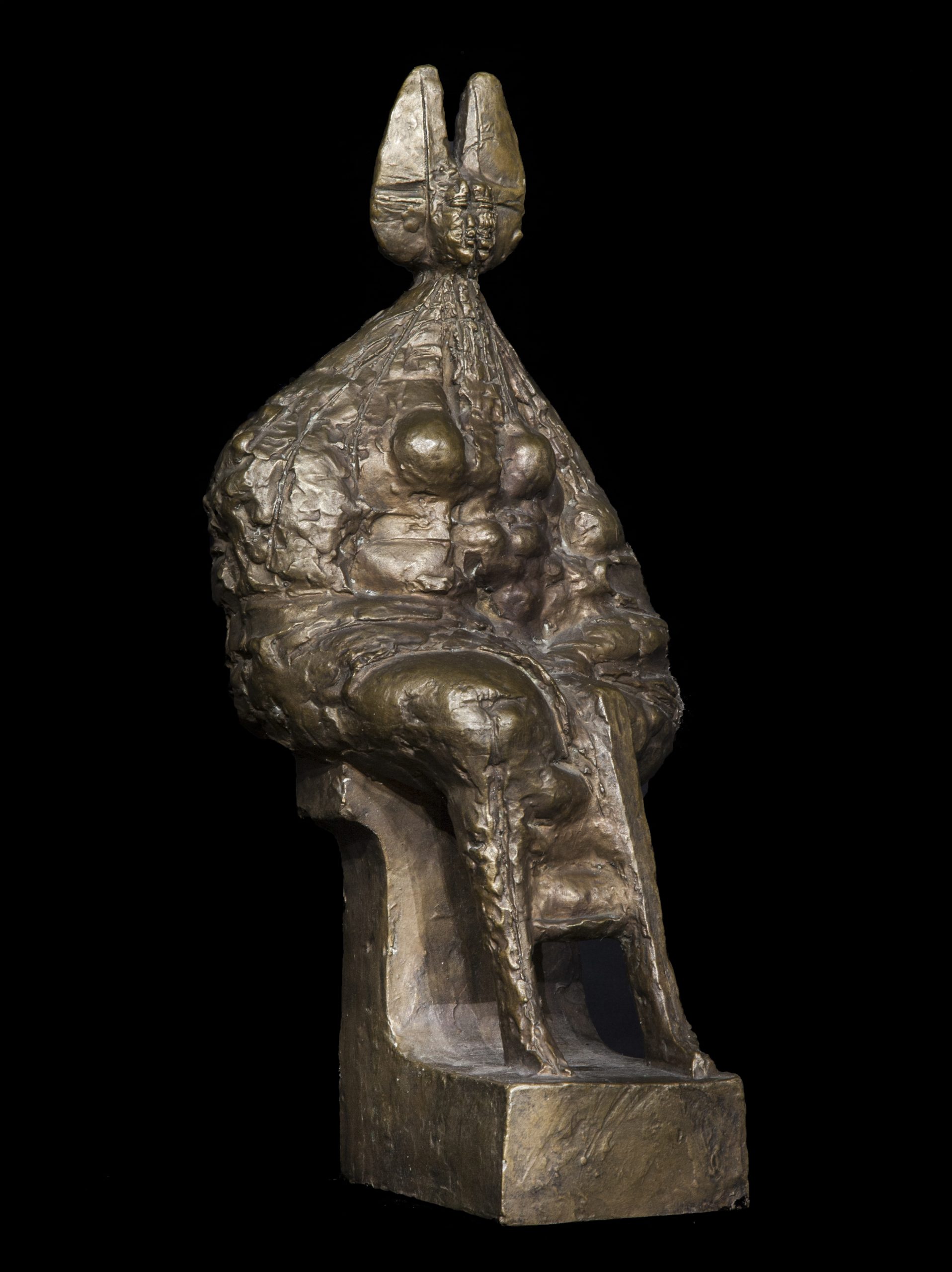A figurative bronze sculpture of an abstract queen sitting down.