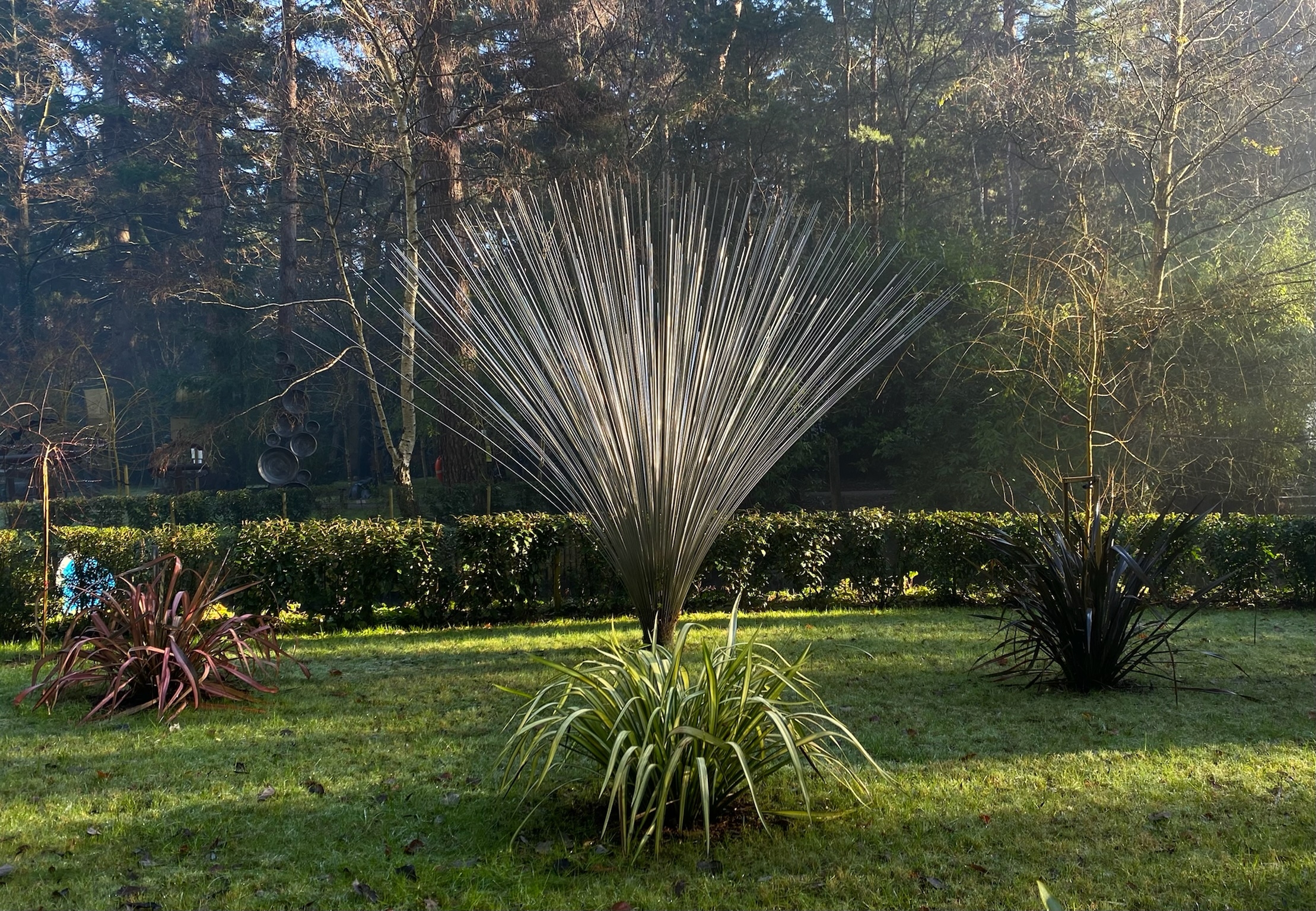 A abstract stainless steel sculpture of a collection of rods that fan out from the centre.