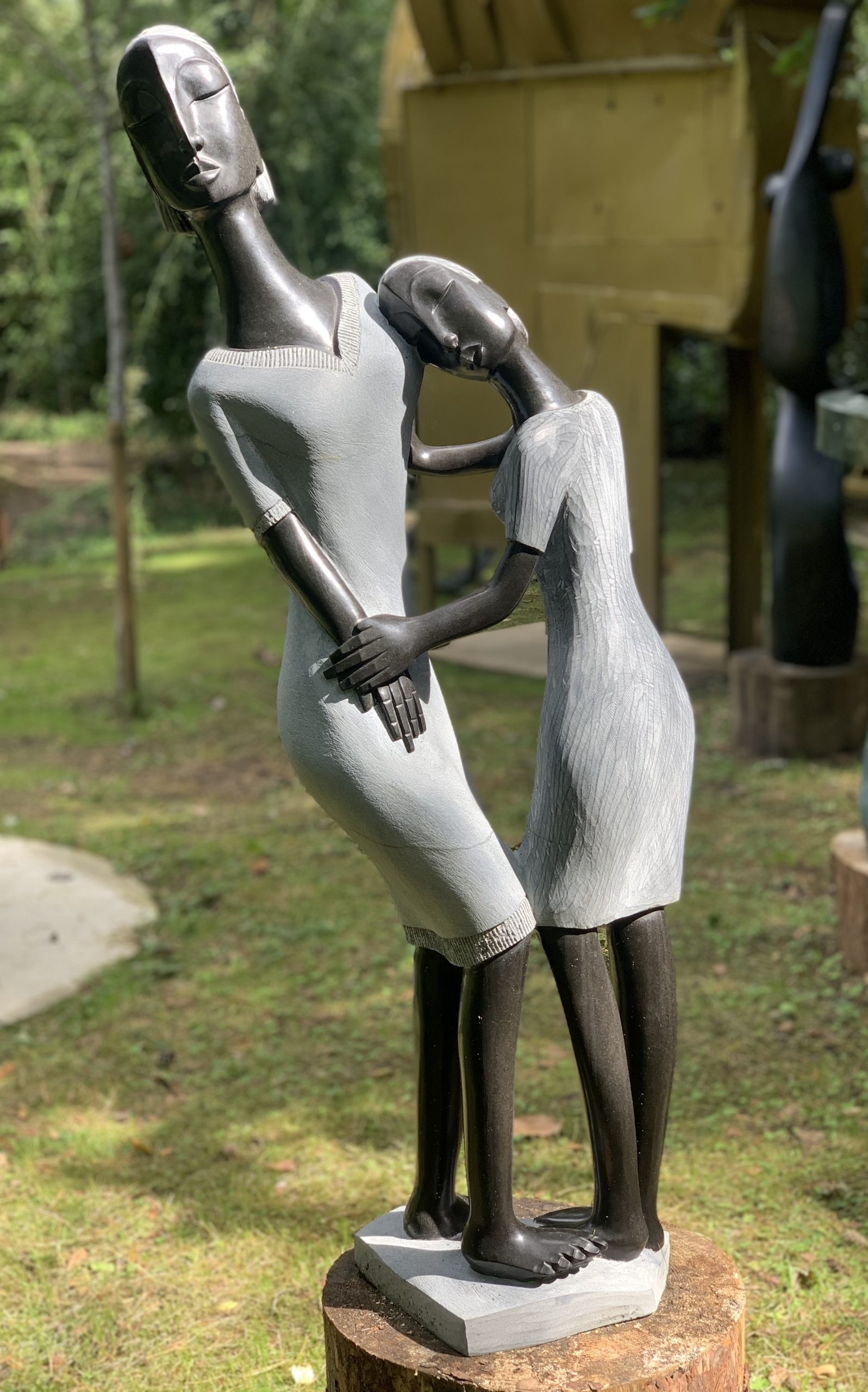 A Shona springstone sculpture of two women holding onto each other.
