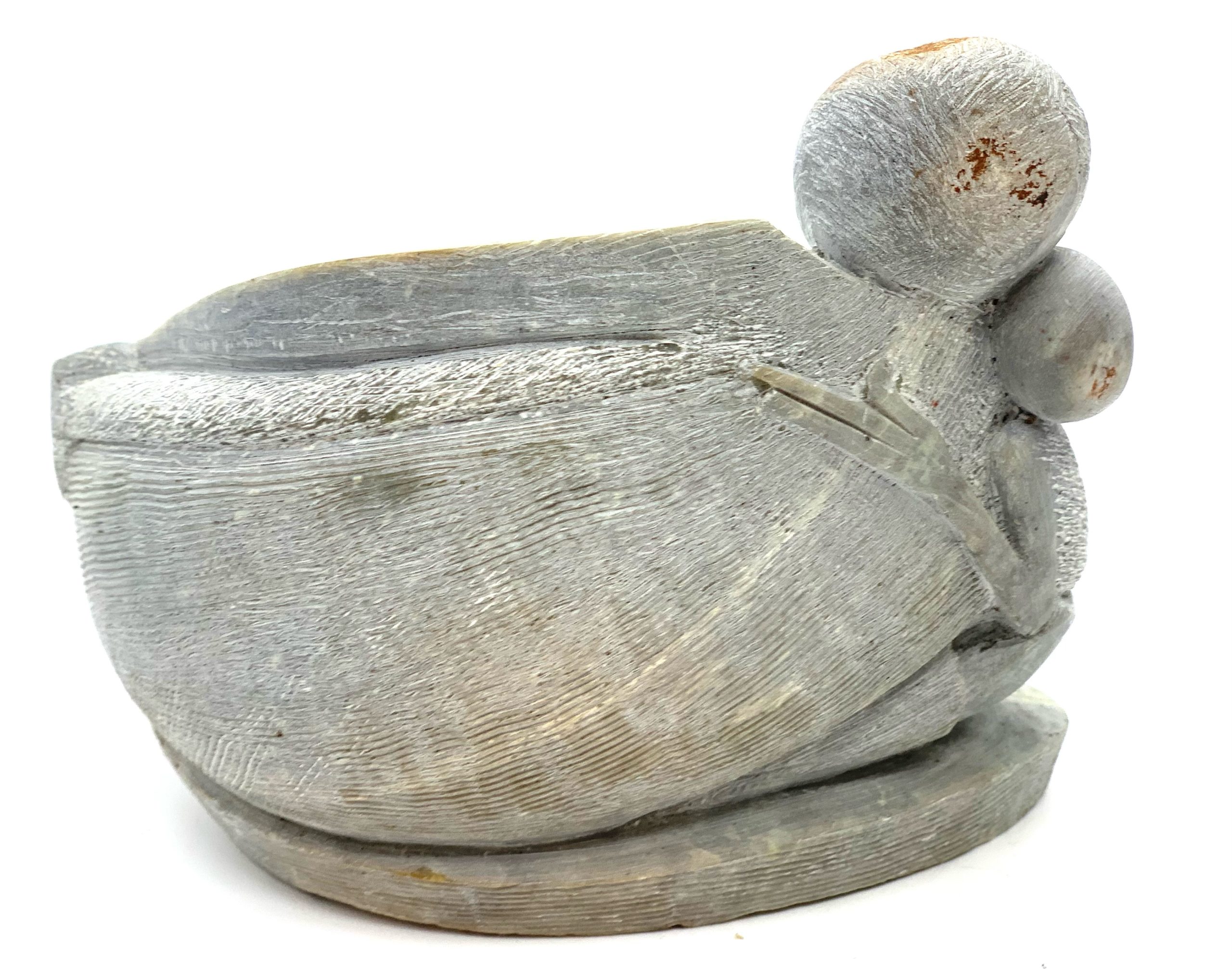 A smaller scale Shona sculpture made of Serpentine stone showing a parent and child in an embrace.