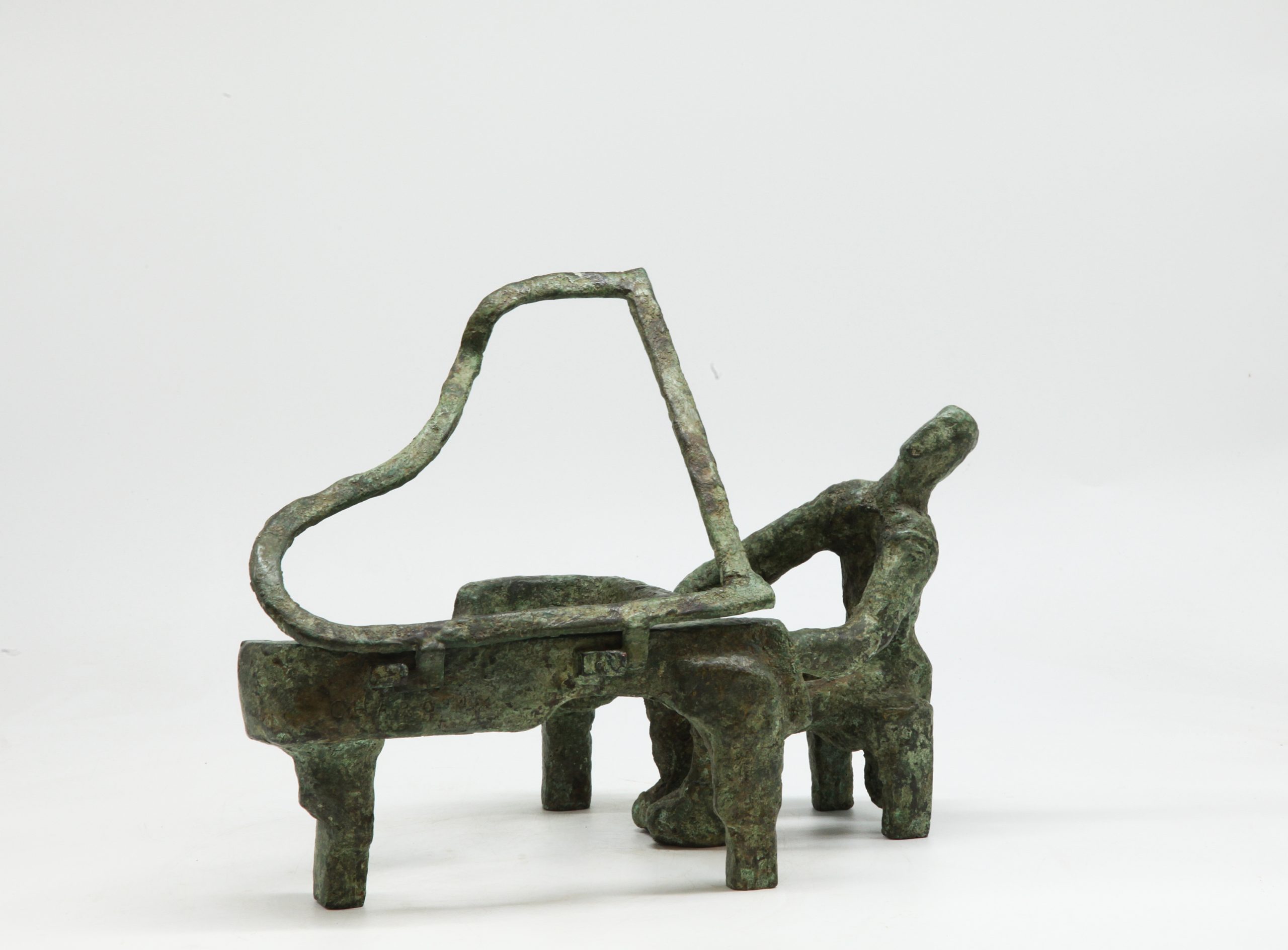 A bronze abstract sculpture of a person sitting down and playing a grand piano.