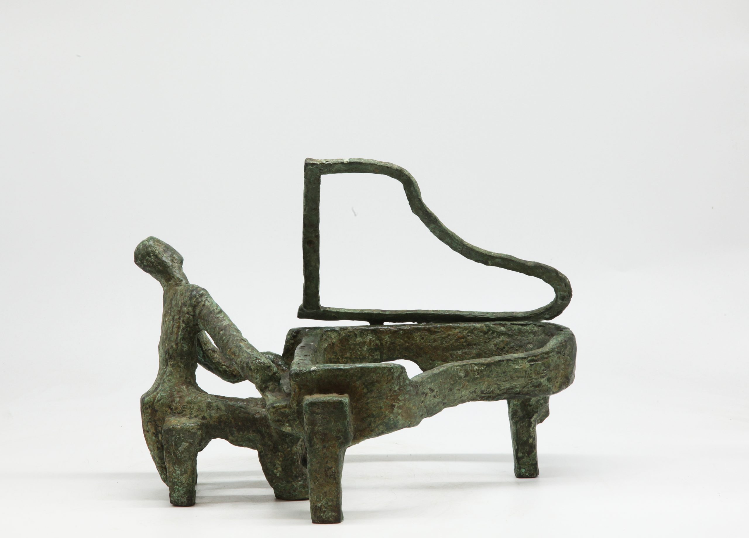 A bronze abstract sculpture of a person sitting down and playing a grand piano.
