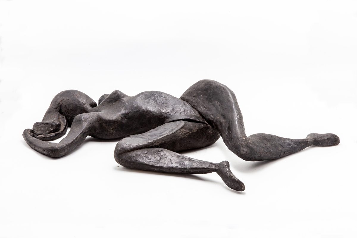 A figurative bronze resin sculpture of a abstract woman lying on her back.