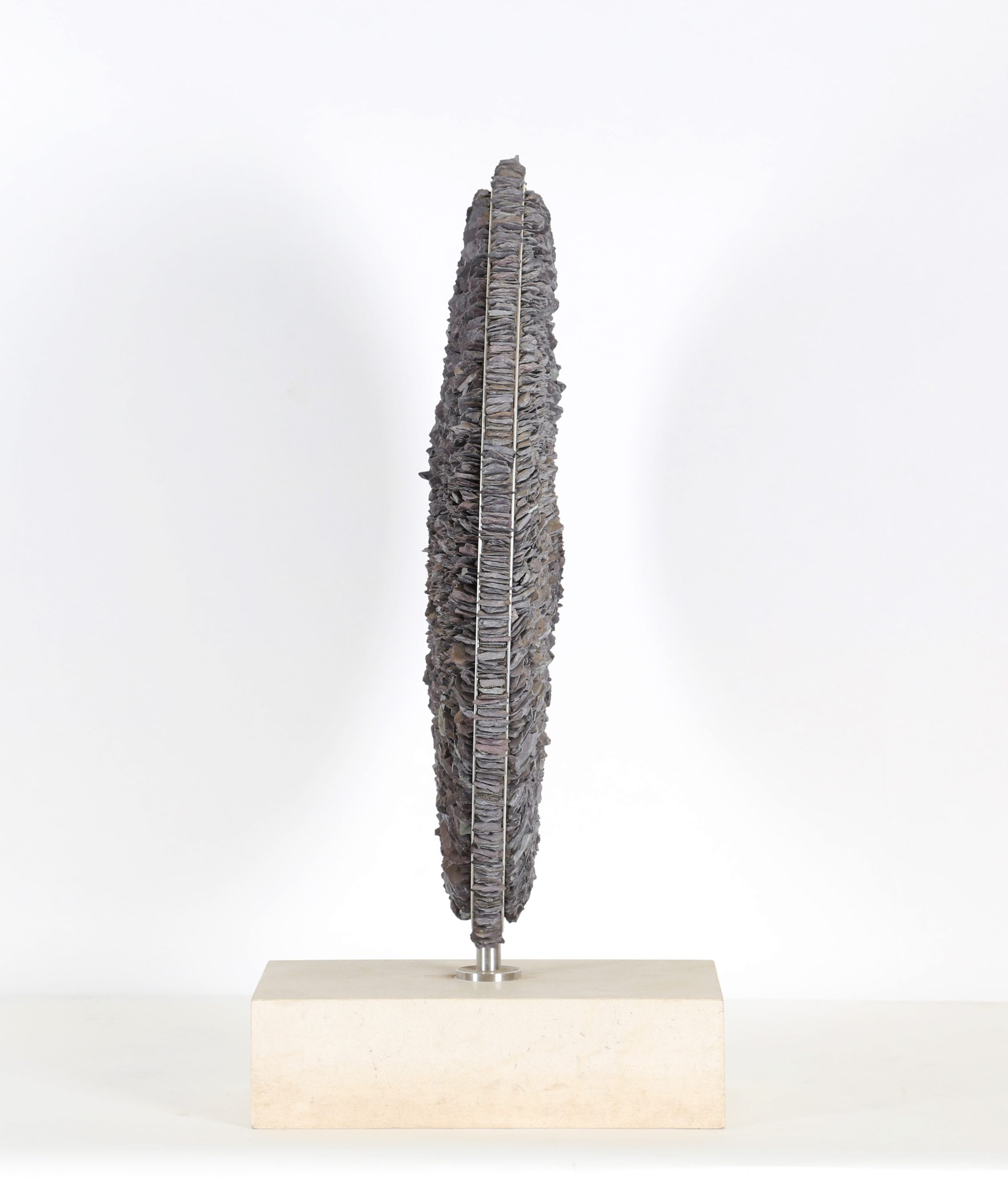 A contemporary stone and metal sculpture of a circle filled with pieces of slate.