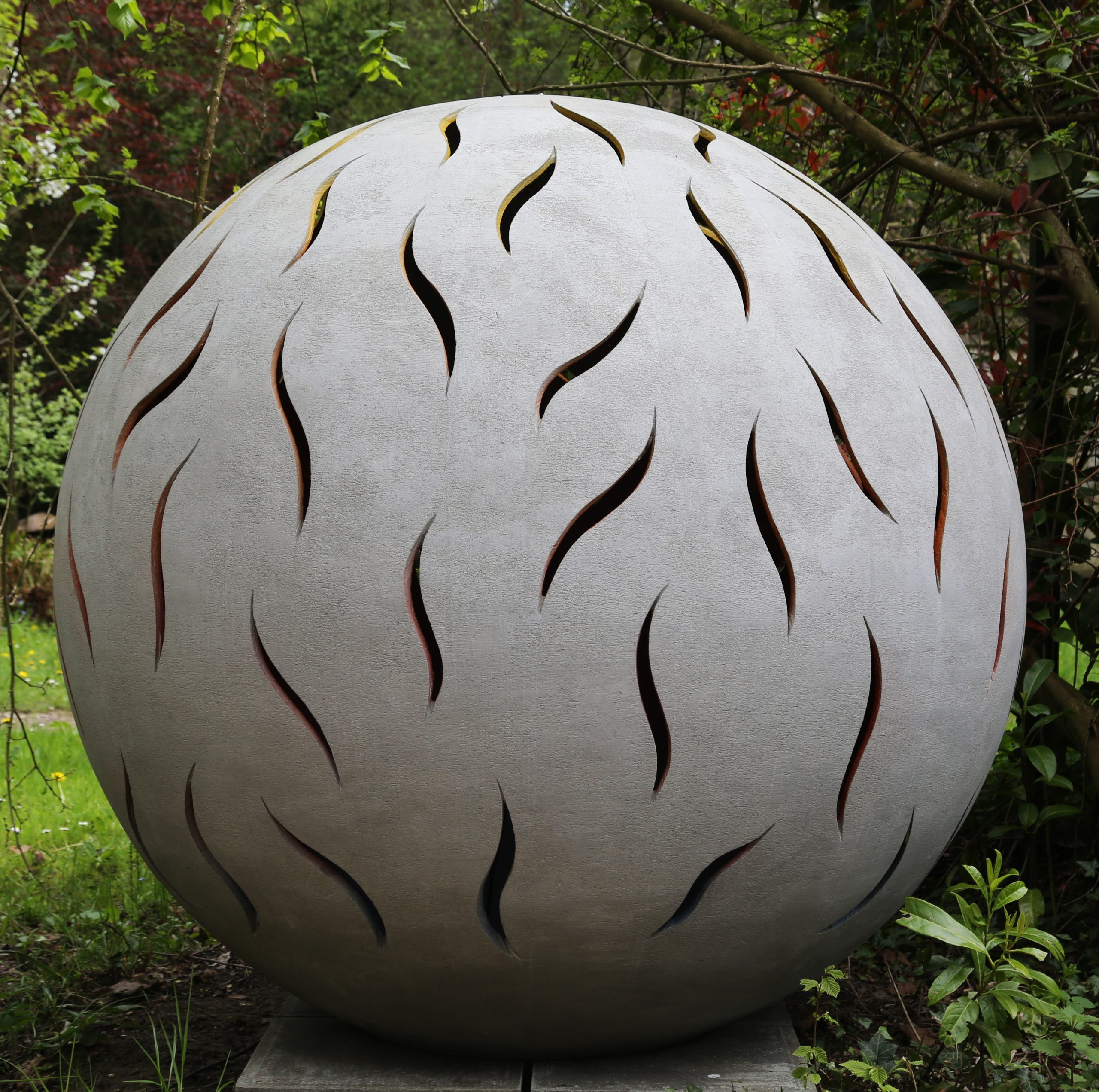 Sphere shaped stoneware sculpture with cut outs around the outside revealing a changing light coming from the inside.