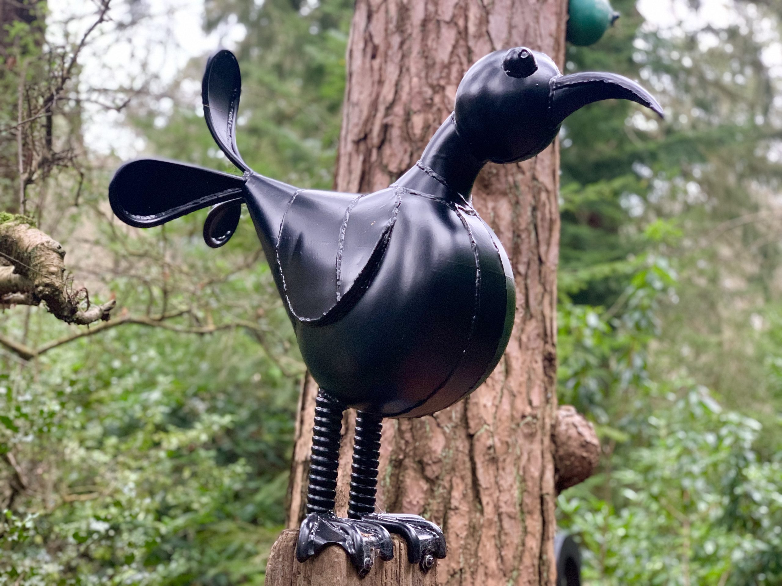 Abstract and Fun Sculpture of a Bird Made from Found Objects Standing on a Tall Plinth