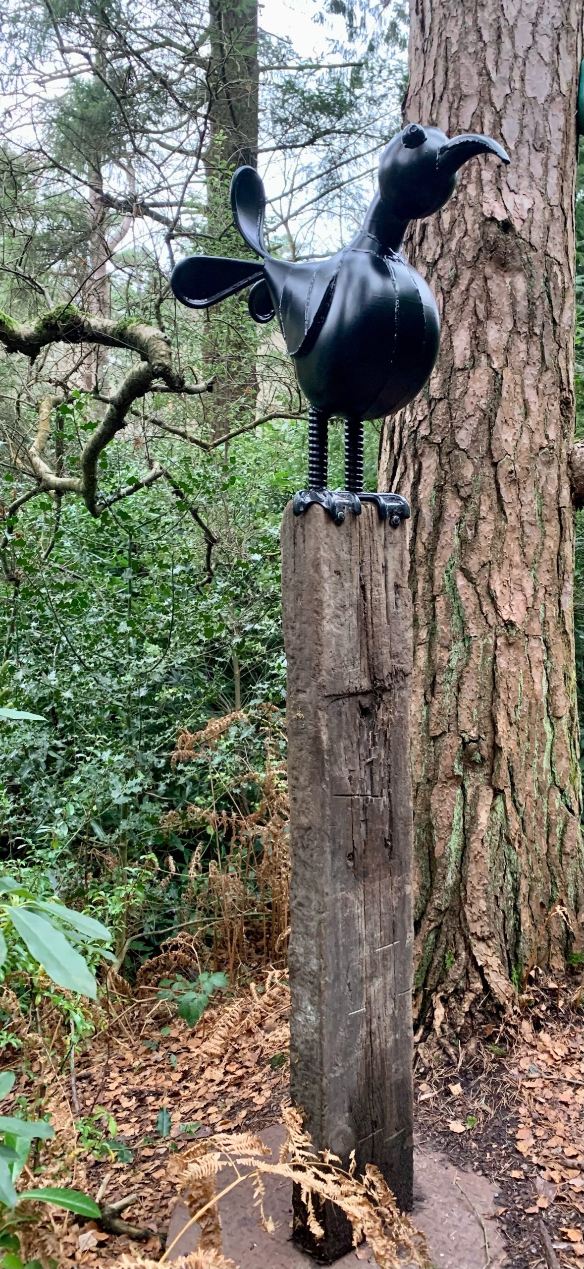 Abstract and Fun Sculpture of a Bird Made from Found Objects Standing on a Tall Plinth