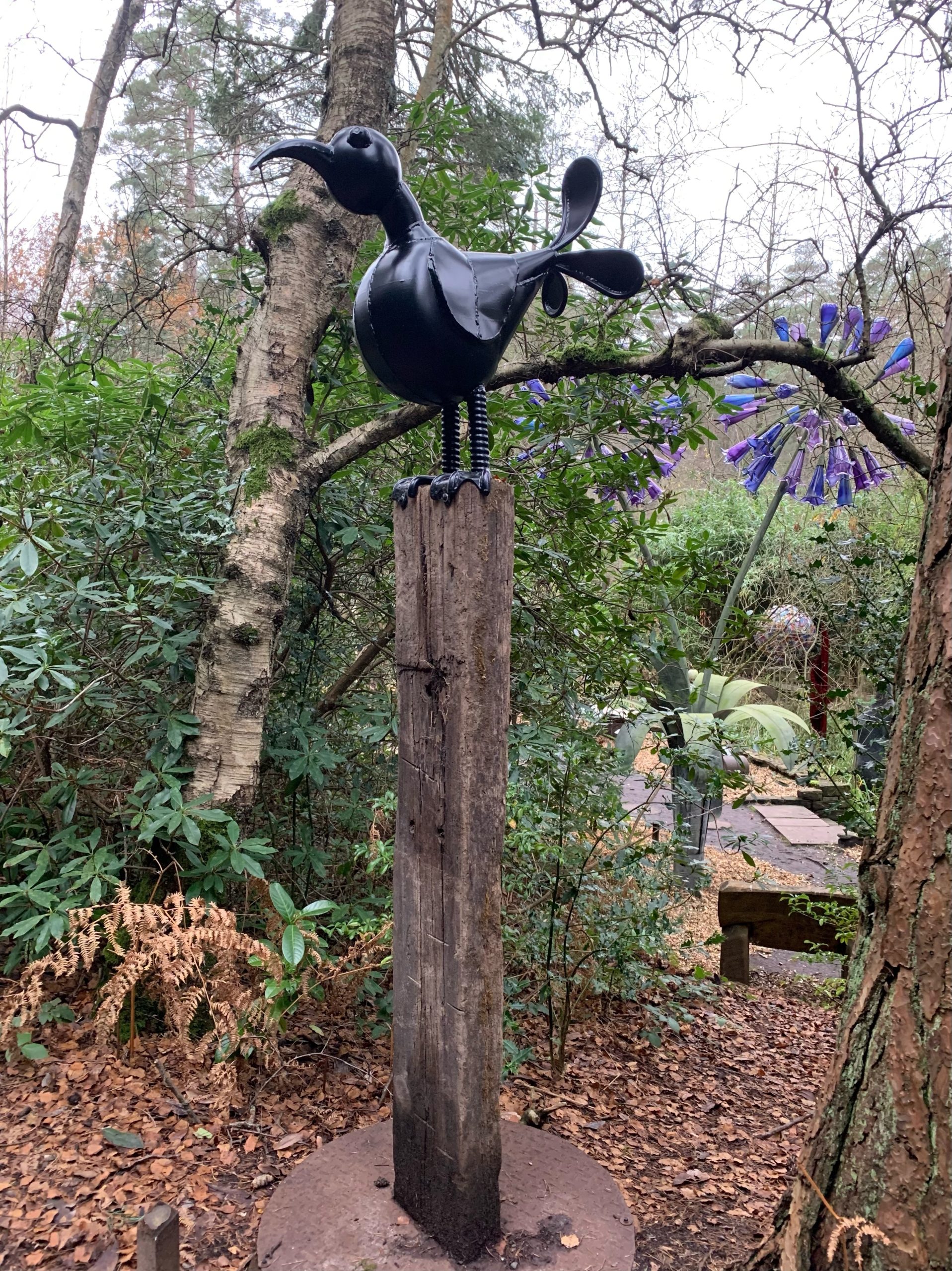Abstract and Fun Sculpture of a Bird Made from Found Objects Standing on a Tall Plinth