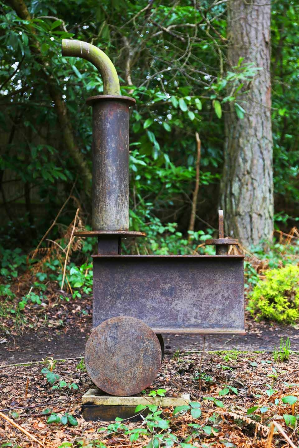 A abstract metal sculpture of a minimalist depiction of a steam train engine.
