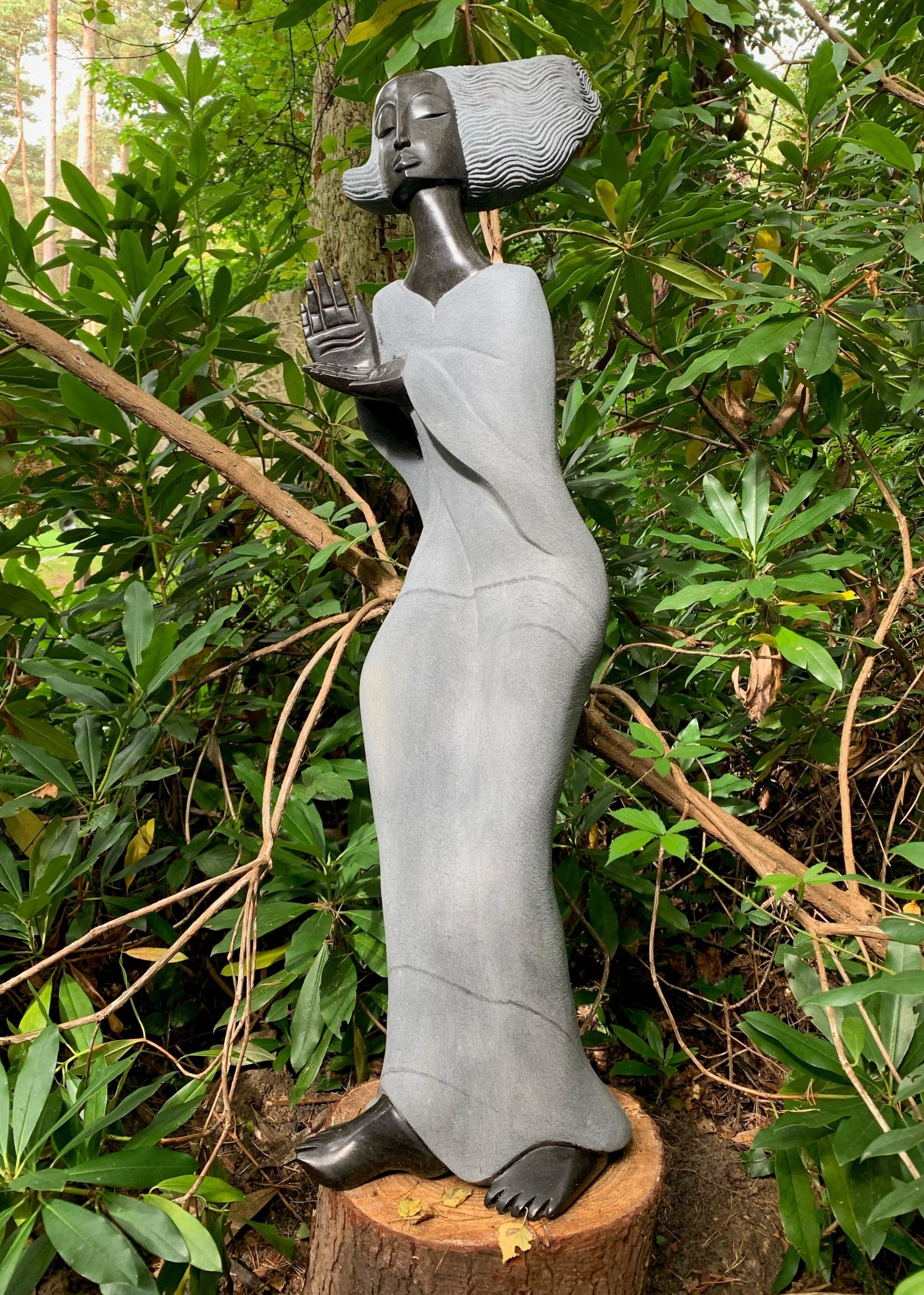A Shona sculpture of a tall woman figure made of Springstone.