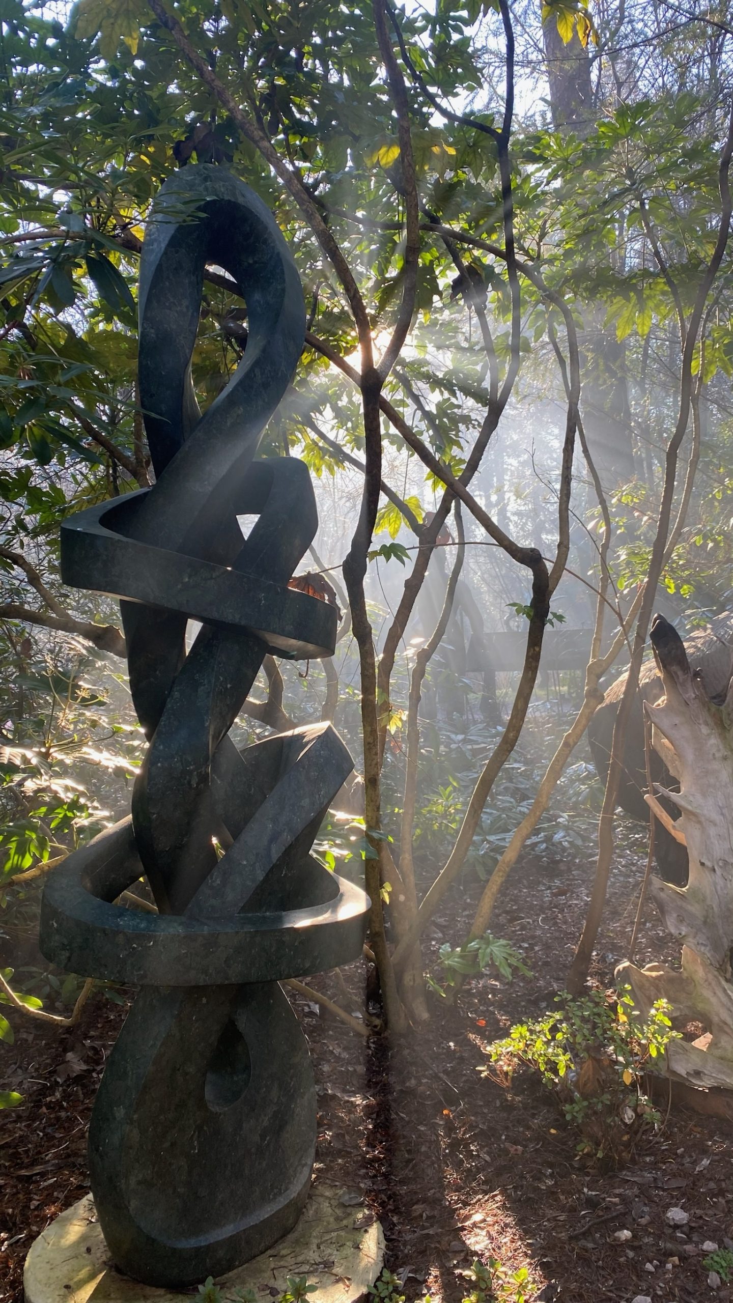 A large abstract Shona sculpture of intertwining shapes. Made of Opal stone.