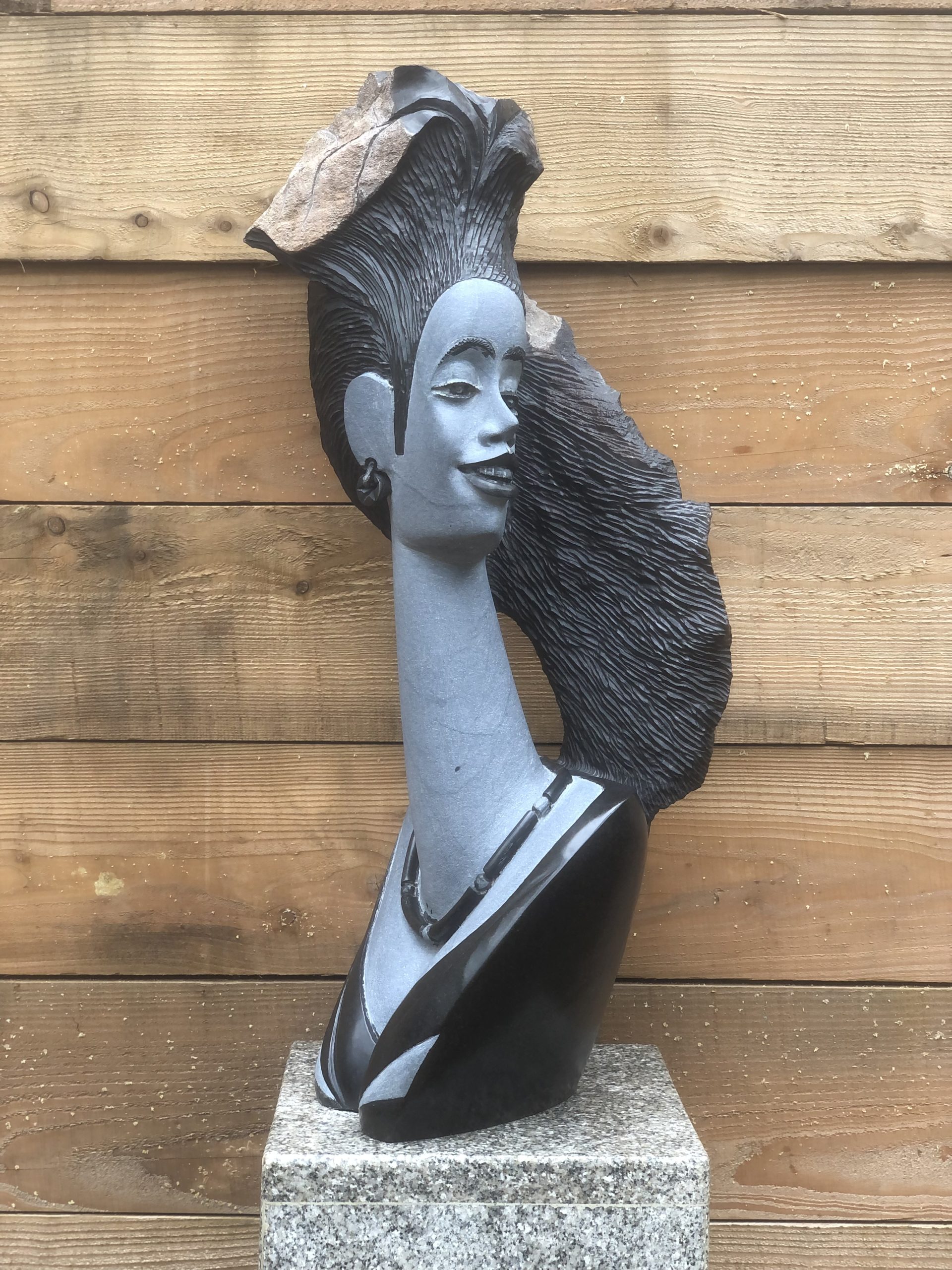 A figurative Shona springstone sculpture of a woman looking over her shoulder.