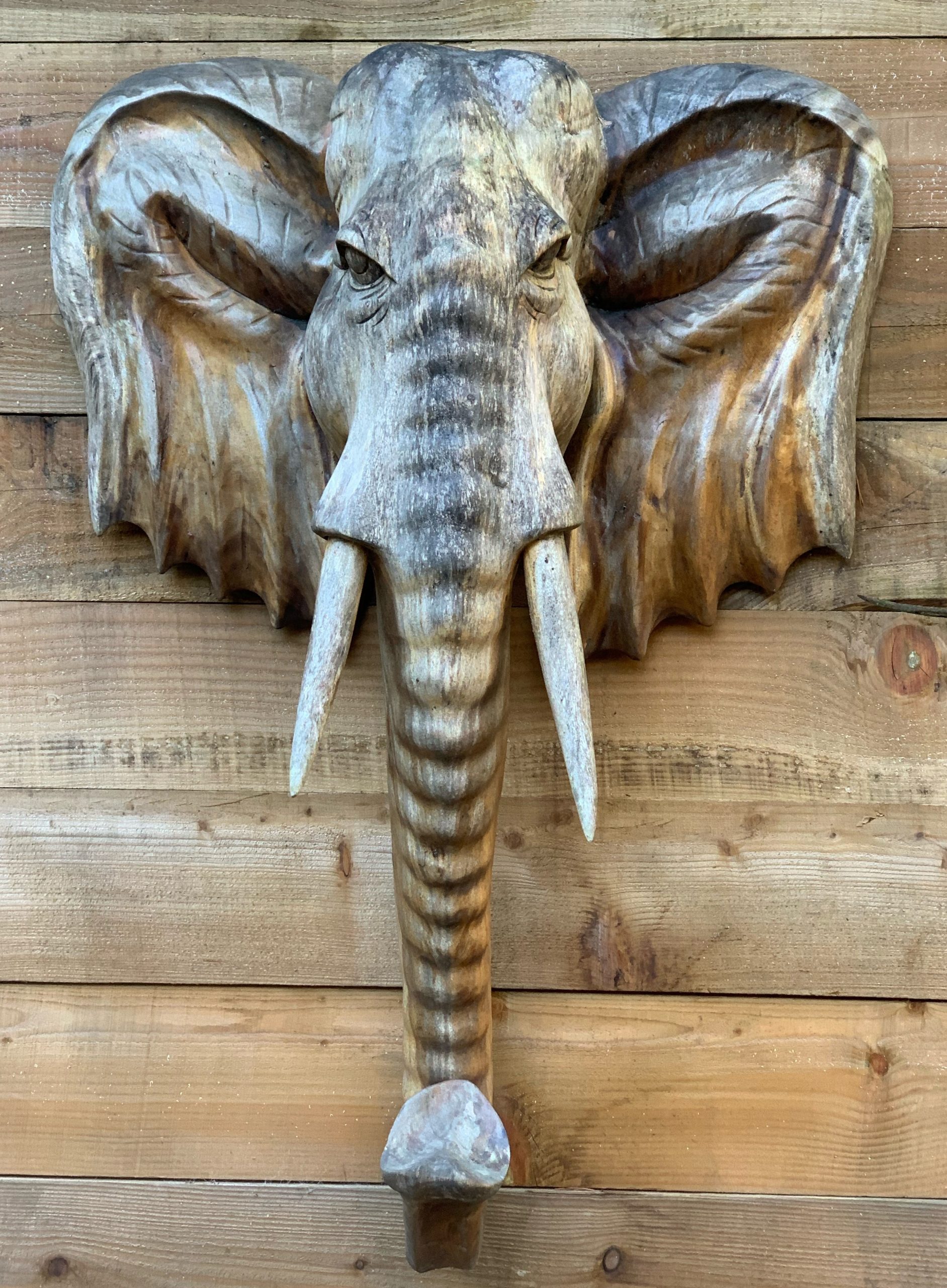Wall Mounted Elephant head is A figurative wall mounted sculpture of a wooden elephant head.