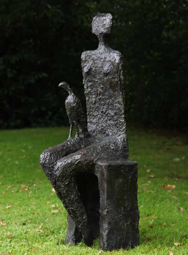 Companion by Wendy Fisher is a simple figurative bronze sculpture of a seated woman with a kestrel bird on her lap.