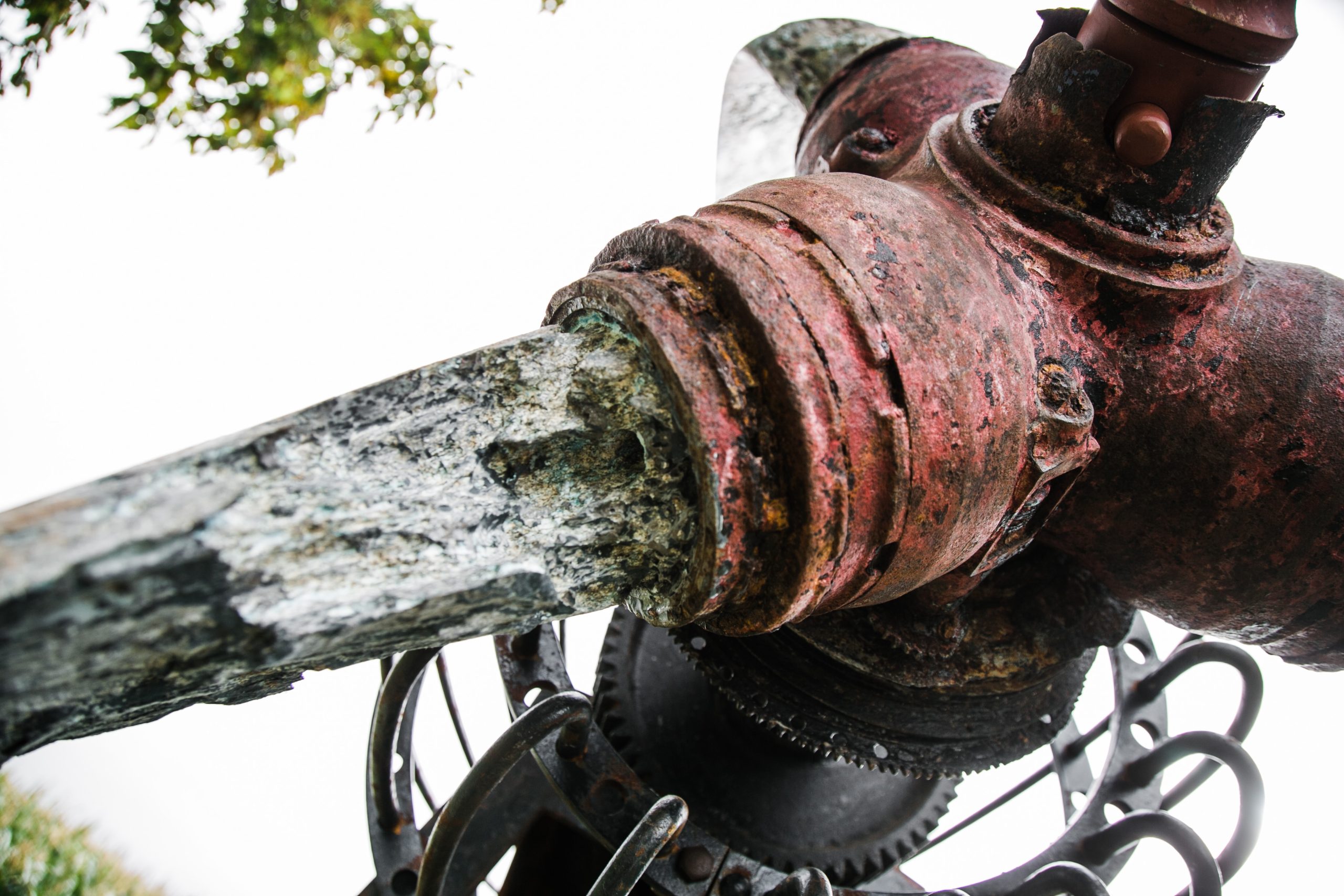 A architectural found object sculpture of a plane propeller mounted onto a metal frame.