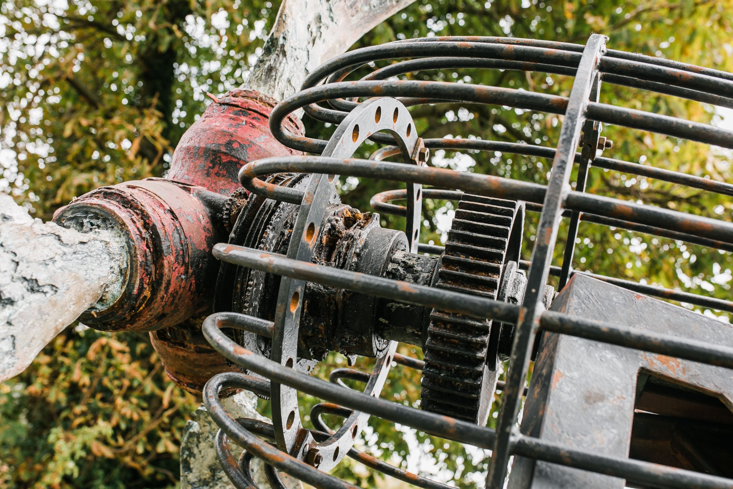 A architectural found object sculpture of a plane propeller mounted onto a metal frame.