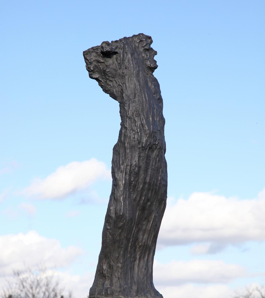 A figurative bronze sculpture of a tall abstract figure.