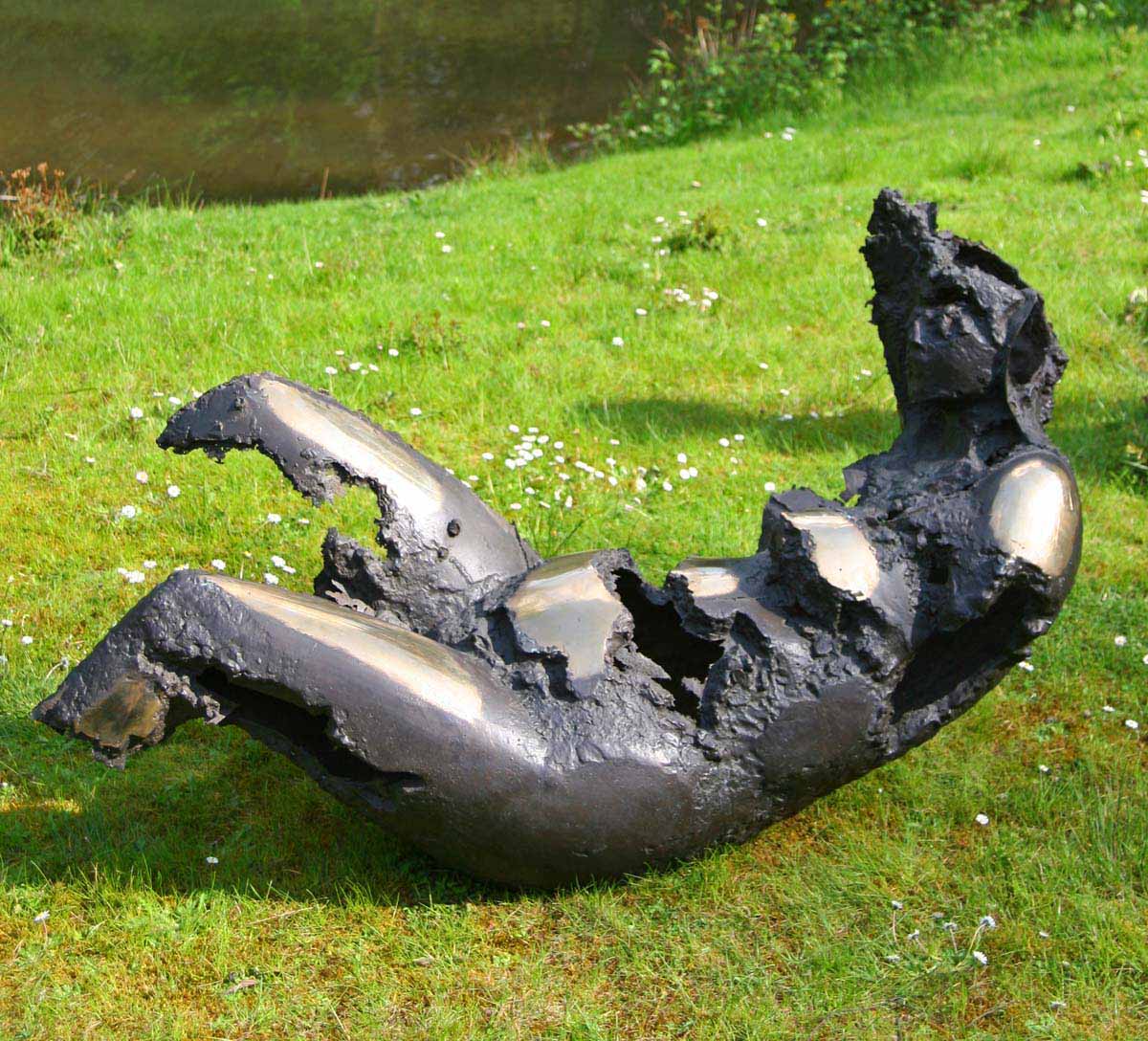 A figurative bronze sculpture of an abstract woman lying and rolling around on the ground.