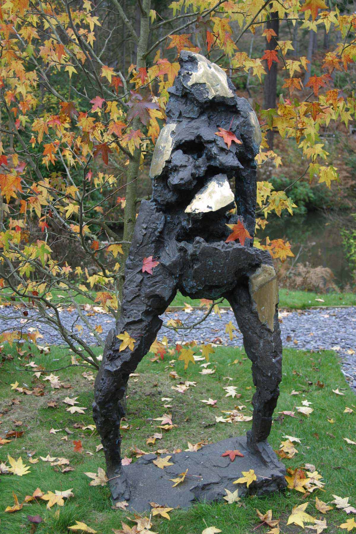 A figurative bronze sculpture of an abstract figure standing.